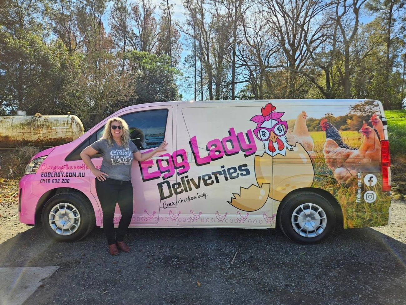 Simone standing next to the pink Egg Lady Deliveries van, with a cartoon hen in pink glasses painted on the side